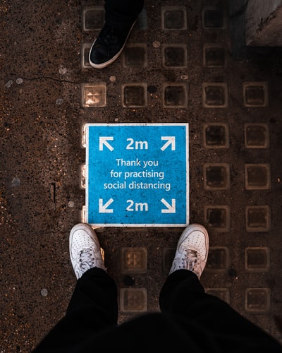 Wearing black pants and a gray shoes standing on the gray cement floor
